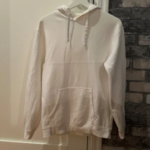 Vit hoodie i ekologisk bomull XS - Vit hoodie från Cubus i ekologisk bomull, storlek XS. Klassisk modell med huva, snörning och magficka. 