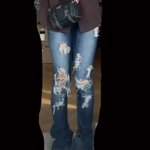 INTRESSEKOLL Mörkblå slitna jeans med bootcut - Säljer ett par mörkblå jeans med rejält slitna och trasiga detaljer över hela benen. Jeansen har bootcut-modell och sitter snyggt på benen. Perfekta för dig som gillar en edgy och trendig stil.