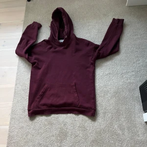 Vinröd hoodie från Pier One - Mysig vinröd hoodie från Pier One med klassisk känguruficka och huva. Tröjan är i mjuk bomullsmix och har långa ärmar, perfekt för kyliga dagar. Enkel och stilren design som funkar till det mesta.