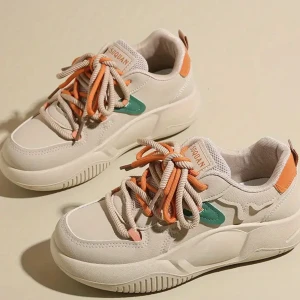 Beige chunky sneakers med färgdetaljer - Chunky sneakers från Suquan i beige syntetmaterial med gröna och orange detaljer. Skorna har tjock sula, rund tå och snörning med tvåfärgade skosnören i beige och orange. Perfekta för dig som gillar en sportig och trendig look.