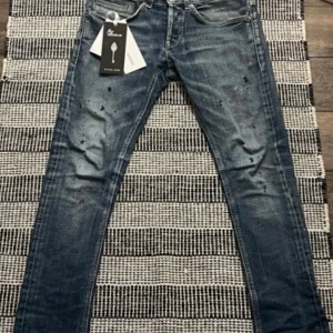 Dondup george paint splatter - Säljer nu mina feta dondup jeans som tyvärr inte passar längre och det behövs att sälja. Du får med tagen.                                                          Passar mellan 168-175 ish. Skriv gärna ifall ni har några frågor!