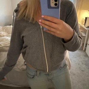 Grå hoodie i kashmir från Filippa K - Mysig grå kofta i kashmir med dragkedja framtill, huva och dragsko. Tröjan har långa ärmar och ribbade muddar. Liten defekt på baksidan som knappt syns (bild 3), i övrigt väldigt bra skick!💕😊 Nypris 3400kr