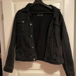 Svart jeansjacka med knappar - Svart jeansjacka i storlek s/m. Har fickor inuti och utanpå och passar perfekt till våren! Säljer då jag inte använder den längre.