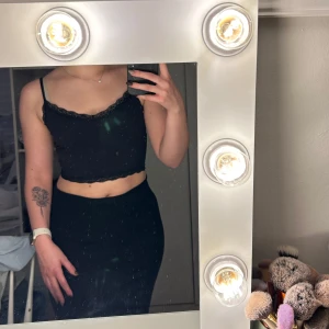 Svart spetslinnetopp från Even&Odd - Svart croppad linnetopp från Even&Odd med tunna axelband och fina spetsdetaljer längs halsringning och nederkant. Storlek xs/sToppen är i mjukt material och har en slim passform som sitter snyggt på kroppen. Perfekt att styla med höga jeans eller kjol.