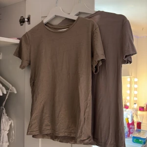 Brun basic t-shirt i bomull - Enkel brun t-shirt i mjuk bomull med rund hals och korta ärmar. Perfekt för en avslappnad stil och lätt att matcha med andra plagg. Snyggt minimalistisk utan tryck eller detaljer.  Priset är för båda!