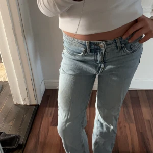 Ljusblå jeans straight fit - Säljer ett par klassiska ljusblå jeans med rak passform. Jeansen har fem fickor, knappgylf och är tillverkade i slitstarkt bomullsjeans. Perfekta för en avslappnad och cool look.