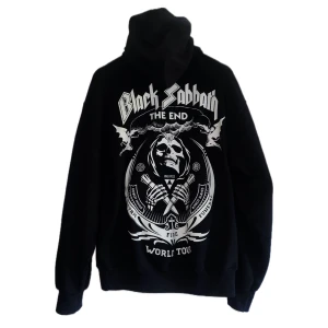 Black Sabbath World Tour hoodie - Svart hoodie med stor vit Black Sabbath 'The End World Tour'-print både fram och bak. Tröjan har huva med snörning och långa ärmar. Grymt tryck med dödskalle och coola detaljer, perfekt för dig som älskar rock och vill sticka ut.