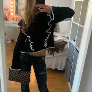 Svart / vit stickad tröja med volang - Svart stickad tröja från H&M Divided med vita volangdetaljer och kontrastkanter. Modellen är croppad med lång ärm och har en loose fit. Perfekt för dig som vill ha något unikt och trendigt i garderoben. Den är andvänd få gånger . Säljs inte längre . Stoltek XS!💞💞💞💝💝💝💘💘💘