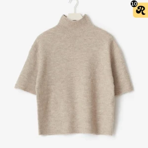 Beige stickad polotröja kort ärm - Helt ny Beige stickad polotröja med prislappen kvar!! Tröjan har korta ärmar och hög krage. Tröjan har en mjuk och mysig känsla, perfekt för lager-på-lager. Enkel och stilren design som passar till många outfits. 