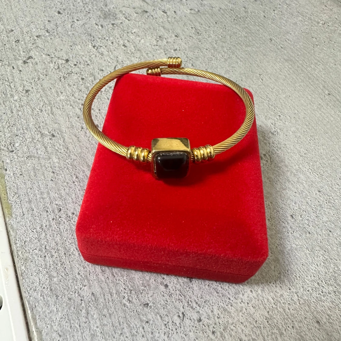 Guldfärgat armband med svart sten