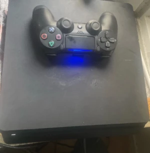 PlayStation 4 - Sony PlayStation 4 med original DualShock 4-kontroll. Konsolen visar tecken på normalt slitage med några ytliga repor, men är i fungerande skick. Perfekt för gaming och multimedia. Kontrollen lyser och verkar vara ansluten.
