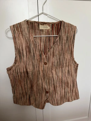 Randig väst  - Cool väst från vitamin kollektion! Aldrig använd. Storlek 38/40. Saknar en knapp. 