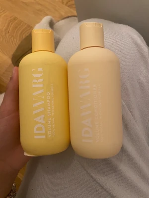 IDAWARG Volume Shampoo & Conditioner - Två flaskor från IDAWARG: Volume Shampoo och Volume Conditioner. Båda är i mjuka pastellfärger, en gul och en ljusgul, med stilren design. 100% veganska och med thickening formula för extra volym. Perfekt för dig som vill boosta håret. HELT OANVÄNT 