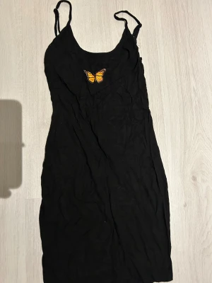 Svart mini klänning - Svart mini klänning med en fjäril som passar xs och s