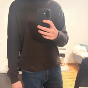 Brun hoodie i kashmir med huva - Mjuk och stilren brun hoodie från Oscar Jacobson i kashmir. Tröjan har en klassisk huva, ribbade muddar och långärmad passform. Perfekt för dig som gillar en clean look med lyxig känsla. Passar dig som vill ha något skönt och snyggt till jeans eller chinos.