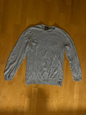 Ljusblå tröja från Oscar Jacobson - Snygg ljusblå tröja från Oscar Jacobson i storlek L. Tröjan har rund hals, ribbade muddar och är långärmad. Perfekt för dig som gillar stilrena och klassiska plagg. Materialet är mjukt och skönt, passar till många olika looks.