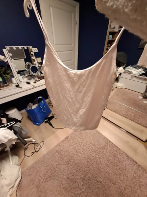 Ljusrosa linnetopp från Gina Tricot - Säljer en ljusrosa linnetopp från Gina Tricot, Basically Basics-kollektionen. Toppen har smala axelband och ärmlös design med enkel, rak passform. Perfekt för varma dagar eller att styla lager på lager. Mjuk och skön känsla. Köpt för 120