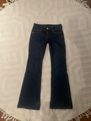 Bootcut jeans från H&M Divided, mörkblå - Mörkblå bootcut jeans från H&M Divided i storlek 36. Trendiga sköna jeans något skadade vid ”hälen” men annars fint skick! Pris kan diskuteras🥰