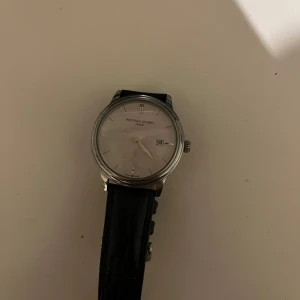 Frederique Constant Slimline - Frederique Constant Geneve Slimline. Klockan är Quartz och är från början av 90-talet, den är därmed lite sliten och batteriet har bytts ut, och behöver göra det igen. Klockan är schweizisk, elegant och tidlös samtidigt som den kommer från ett etablerat märke, men inte en av de största tillverkarna, och till ett bra pris. Läderbandet fungerar som den ska och har ett snyggt mönster! Värde ca 6-7 tsn. Priset går att diskutera eller bytas mot annan klocka!  