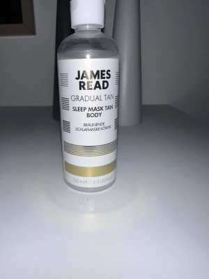 James Read Sleep Mask Tan Body 100ml - James Read Gradual Tan Sleep Mask Tan Body är en lyxig brun-utan-sol för kroppen. Kommer i en genomskinlig plastflaska med vit och guldig etikett. Innehåller 100 ml och ger en gradvis solkysst look medan du sover.