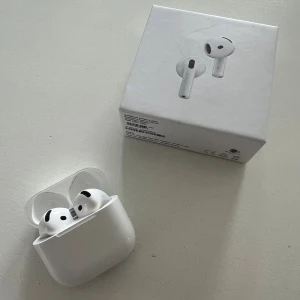 Trådlösa hörlurar 4 – originalförpackning - Trådlösa hörlurar med enkel och stilren design. Ger bra ljud och stabil koppling. Säljs i originalkartong tillsammans med laddningsetui. Priset kan diskuteras. Levereras snabbt och välpackat. Fråga gärna!