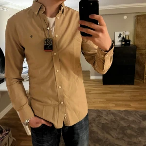 Morris skjorta - Tjena! Säljer en extremt snygg och skön Morris skjorta. Den är helt ny med prislappen på. Skjortan är i färgen brun/beige. Märket är mörkbrunt. Storlek S men skulle säga mer en M. Den är perfekt till alla lägen! Nypris runt 1800 kr Hör av dig vid funderingar🙌