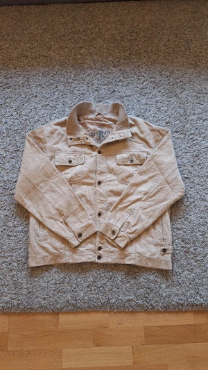 Beige overshirt med bomullsstoppning från Reserved - Snygg varm beige overshirt med bomullsstoppning från Reserved i storlek M(passar L också). Använd fåtal gånger och skicket är riktigt bra, inga defekter eller slitningar finns. Den har åtta knappar samt fyra fickor. Den är riktigt varm nu under vintern då den har bomullsstoppning och passar perfekt för dig som både vill hålla dig varm och vara stilig nu under vintern och Jul! Skick: 8.5/10