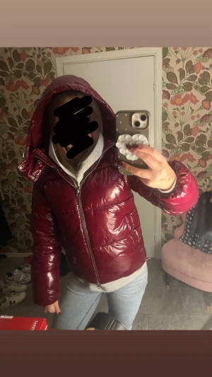 Vinröd pufferjacka från Nelly XS - Säljer en glansig vinröd pufferjacka från Nelly i storlek XS. Jackan har huva, dragkedja framtill och en riktigt snygg, quiltad look. Perfekt för kalla dagar när du vill sticka ut lite extra.
