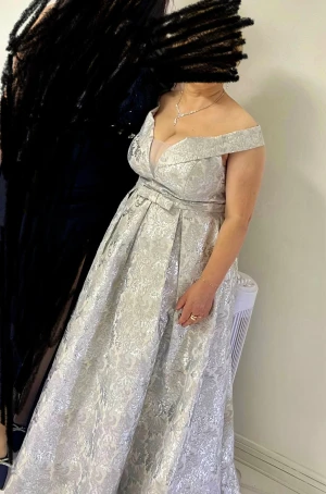 Silverfärgad långklänning med offshoulder. - Elegant wedding guest långklänning i silver med vackert brokadmönster och offshoulder-skärning. 