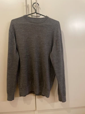  Zara tröja - En stilren grå stickad tröja från Zara med rund halsringning och långa ärmar. Tröjan är i mjukt material och har ribbade muddar vid ärmslut och nederkant. Perfekt för lager-på-lager och enkel att matcha med jeans eller chino och är bra till vintern 