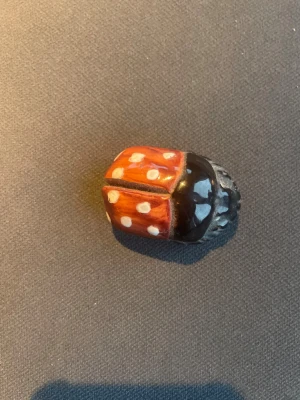 Handgjord nyckelpiga i lera - Supergullig nyckelpiga, handmålad i rött, svart och vitt med prickigt mönster. Tillverkad i lera. Fin prydnadssak