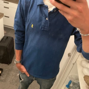 Ralph Lauren Pikétröja  - Riktigt fet blå pikétröja från Ralph Lauren, passar perfekt nu för slutet av sommaren! 🙌 Pikétröjan är endast använd ett fåtal gånger. Personen i annonsen är dessutom 179 och väger 55 kg. Skick - 10/10 Säljs för 350kr.