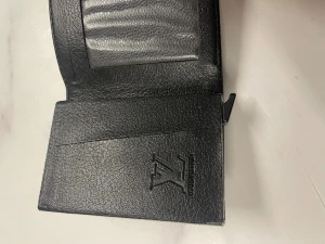Svart Plånbok  - En svart plånbok med mönster som har aldrig använt kanske bara en gång och priset kommer alltid att diskuteras 