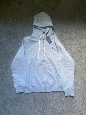 Ralph louren zip hoodie - Säljer en riktigt fräsch hoodie från Ralph louren hoddien e helt oanväd och har kvar lappen.Hör av er vid mer frågor:)