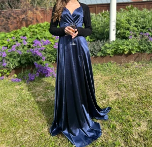 Marinblå långklänning med slits  - Snygg marinblå långklänning i glansigt material med v-ringad hals och smala axelband. Klänningen har en hög slits på ena sidan, fin för en bal eller fester 🤗säljs för 480, originalpris runt 700 kronor 