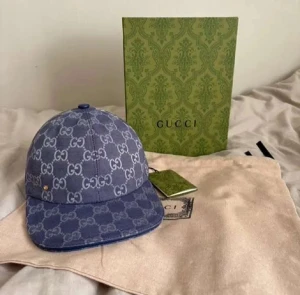 Blå Gucci keps med GG-mönster - Snygg blå keps från Gucci med det klassiska GG-mönstret över hela kepsen. Kepsen har en böjd skärm och är tillverkad i bomullsmaterial. Perfekt för dig som vill ha en lyxig och trendig accessoar med tydlig designerstil.