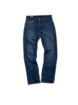 Levi's 501 jeans - Klassiska Levi's 501 jeans i mörkblå tvätt med raka ben och fem fickor. Byxorna har knappgylf, bruna sömmar och den ikoniska läderpatchen bak i midjan.                                                                               Hör av dig vid frågor!