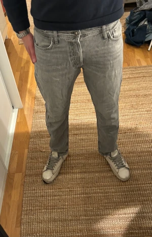 Ljusgrå jeans från Jack & Jones - Säljer ett par ljusgrå jeans från Jack & Jones. Jeansen har en normal midja och är tillverkade i mjukt bomullsmaterial. Snygg tvättad look och stilrena detaljer. Jeansen är endast använda ett fåtal gånger och är därför i mycket bra skick! Tveka inte att höra av dig om du har någon fråga eller ett prisförslag!