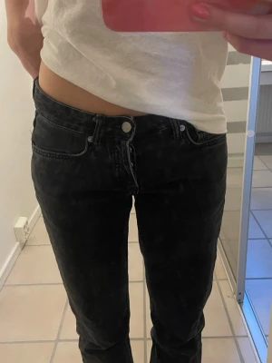 Svarta raka jeans  - Säljer ett par svarta raka jeans med klassisk rak passform och låg midja. Jeansen har fem fickor, knappgylf och är gjorda i slitstarkt jeanstyg. Perfekta till sneakers eller boots och ger en clean look till vilken outfit som helst. Köpte från laget 157 i icon modellen med strl Xs. Jeansen är uppsprättade nertill 