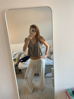 Beige blus med knyt från 157 - Supersöt beige blus från 157 i storlek XS. Den har v-ringning, korta volangärmar och knyt i ryggen. 