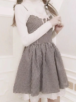 Rutig svartvit kortklänning med spets - Sparsamt använd. Fint skick. Har en liten fläck men inget som syns när man bär klänningen. Storlek "F" men shirring i bak så uppskattar att den passar XXS-S. Skickar med en matchande choker.