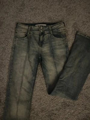 Blå jeans med pressveck från Bershka - Säljer ett par jätte fina low waits bootcut jeans från BERSKHA i storlek 38