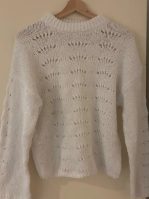 Vit stickad tröja med hålmönster - Superfin vit stickad tröja från Cubus med hålmönster över hela tröjan. Tröjan har en ribbad rund halsringning och långa ärmar. Perfekt för lager-på-lager och ger en mysig vibe till din outfit. Passar som storlek S.
