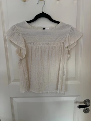 Vit blus med spets från H&M Divided - Säljer en söt vit blus från H&M Divided i storlek S. Materialet är lätt och krinklat. Toppen har inga tecken av användning, skriv för fler frågor eller bilder🤍