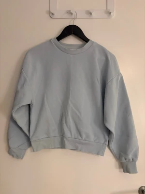 Dam ljusblå sweatshirt  - Säljer en ljusblå sweatshirt från GinaTricot i storlek XXS. Väldigt skönt material och en basic sweatshirt som matchar allting. Den har 2 små ”fläckar” som man ser på sista bilden som kan gå bort i tvätten men kan inte lova något, dom syns inte när man använder den. 