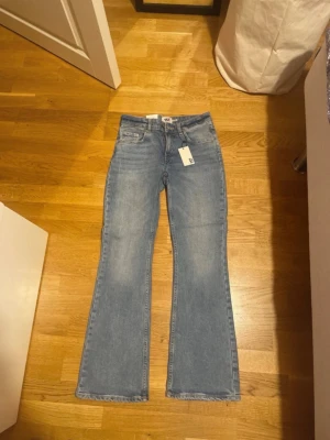 Bootcut jeans i ljusblå denim från 157 - Bootcut jeans från lager 157 i ljusblå tvättad denim. Modellen är lågmidjad med klassisk femficksdesign som är bootcut. Perfekt för alla som vill ha ett par basic low waist bootcut. Prislapp är kvar. Köpta för 400kr
