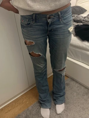 Ljusblå slitna bootcut jeans Hollister - Säljer ett par snygga ljusblå bootcut jeans från Hollister. Storlek W27 L33. De är lagande av en skräddare, på grund av tidigare hål. (Se sista bilden) men ingenting som märks av. Skriv för fler bilder eller vid funderingar❣️