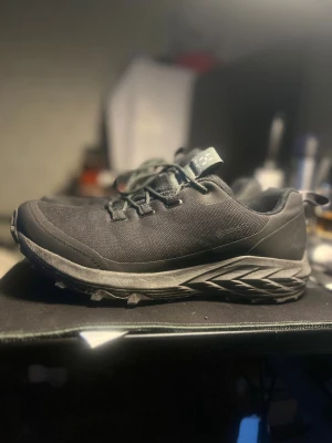 Svarta sneakers från Haglöfs - Svarta sneakers från Haglöfs med slitstark textil och syntetmaterial, robust sula med FlyteFoam-teknologi och grovt mönster för extra grepp. Skorna har snörning och rund tå, perfekt för dig som gillar outdoor och äventyr.