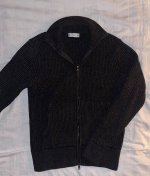 Mörkbrun stickad kofta från Mango - Ribbstickad och tjock zip up från mango, perfekt till vintern. Storleken är small men skulle säga att den sitter som en xs. Vid fler funderingar eller bilder är det bara att höra av sig!