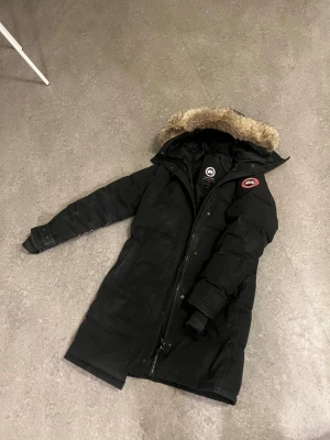 Svart dunjacka från Canada Goose - Säljer en svart lång dunjacka från Canada Goose. Jackan har dragkedja, knappar och flera fickor. Perfekt för kalla vinterdagar! Klpt från Johnells. Upphämtning går också i Stockholm. Pris kan diskuteras. 